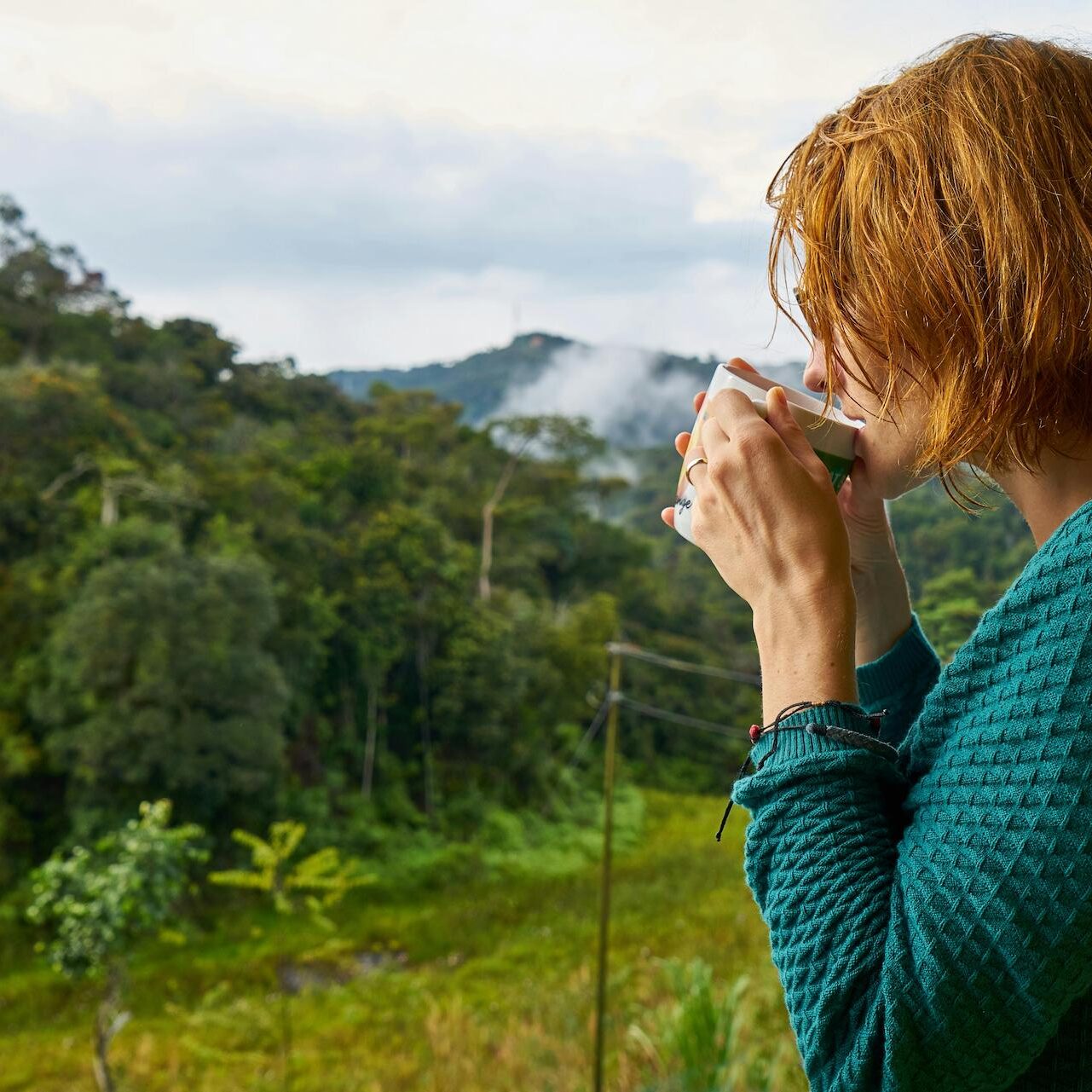 Image of a woman holding a cup of coffee and taking a sip